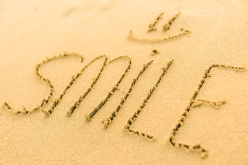 Signs on sand beach written by hand, inspire to travel to exotic islands and relax. Words Ocean, fun, happy and smile on yellow beach. Family tour travel time in summer resort. Enjoy your holidays