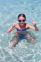 Ragazzina con occhialini da nuota che fa il bagno