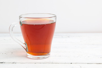 glass cup with tea on white table