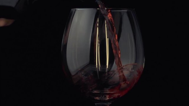 pouring wine from a bottle into a glass slow motoin