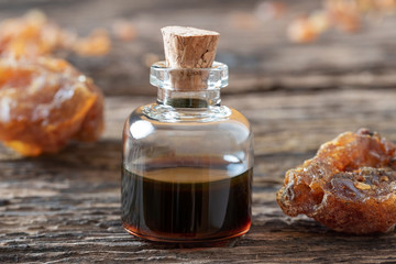 Fototapeta na wymiar A bottle of myrrh essential oil with myrrh resin crystals