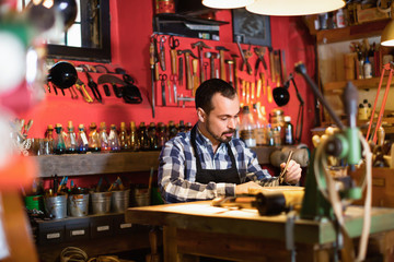 Obraz premium Male worker working on leather for belt in leather
