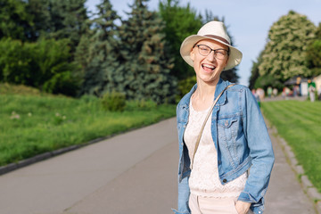 Happy young caucasian bald woman in hat and casual clothes enjoying life after surviving breast...