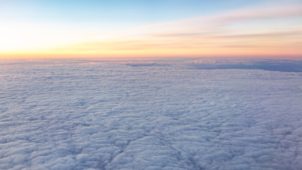 Fototapeta na wymiar Beautiful pink sunrise over the clouds, view from the plane.