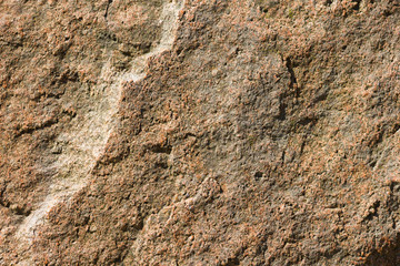 Background of granite. Texture of granite stone. Pattern of roughened surface. Texture of brown stone