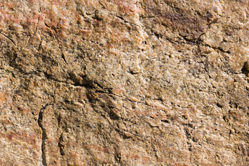 Background of granite. Texture of granite stone. Pattern of roughened surface. Texture of brown stone
