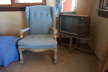 Fototapeta na wymiar KERN COUNTY, CALIFORNIA/UNITED STATES – SEPTEMBER 3, 2016: A vintage TV and chair at Robbers Roost, a ghost town and roadside attraction, Kern County California.