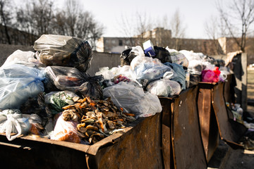 garbage bins are overfilled with packages with waste