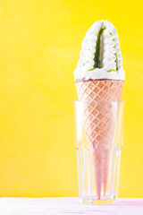 Ice cream cone, summer concept. Ice cream with jam on colored background. Waffle cone with dessert in glass. Side view. Minimal concept