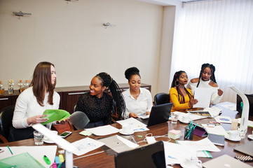 Multiracial women colleagues, crew of divercity female partners in office sit at the table.