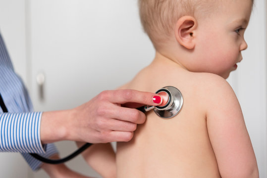 Paediatrician using stethoscope on girl
