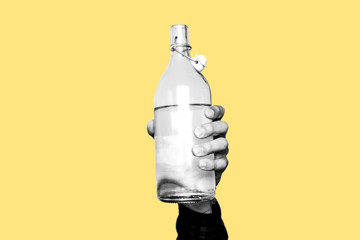 Concept of drought, running out of water, dry summer, global warming. Hand holding a glass bottle...