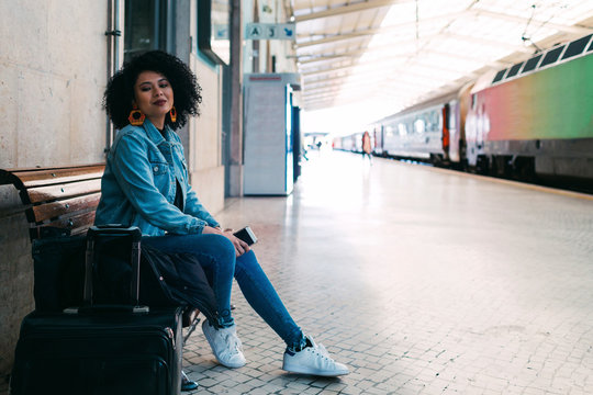 Young woman holding smart phone on railway platform