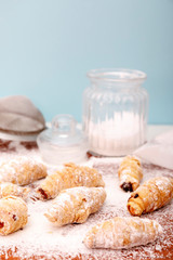 Homemade mini croissants on a wooden kitchen table. Confectionery menu concept. Food bloggers background.
