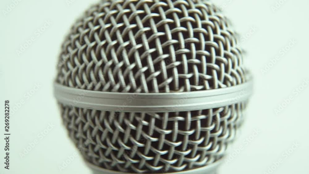 Poster close up of a dynamic microphone spinning against a plain background