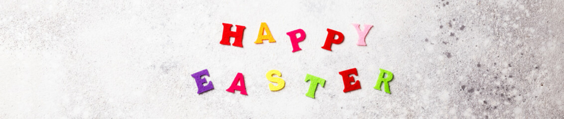 Easter holiday concept on a gray background. Inscription in colored letters.Spring mood.Banner.