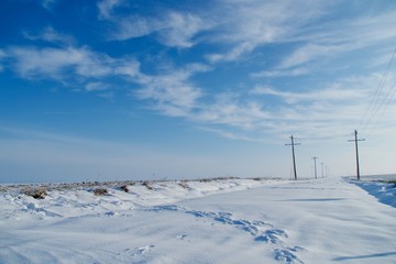 rural snow covered landscape with power lines 