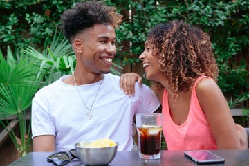 young lovers celebrating their anniversary at a restaurant. Cheerful loving couple having fun at a summer terrace