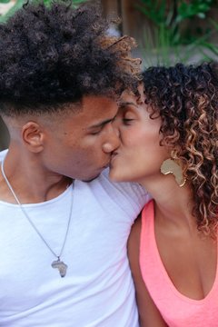 african couple kissing in public. Vertical photo of a young ethnic couple kissing in public
