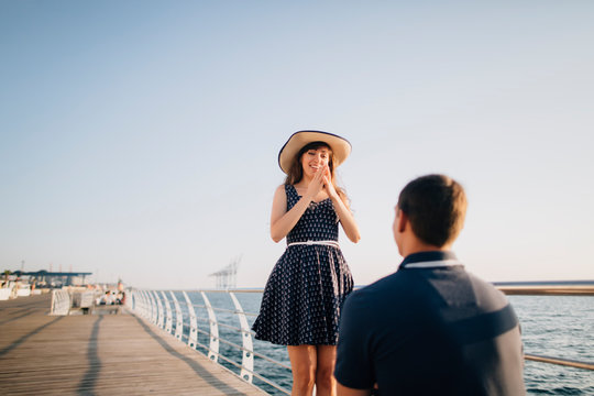 Man proposing to woman on pier