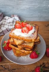 French toast with fresh strawberries, coconut shreds and honey, on wooden background