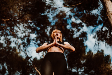 .Young and pretty woman doing yoga outdoors in the middle of nature a nice spring afternoon. Relaxation, deep breathing and calm. Lifestyle.