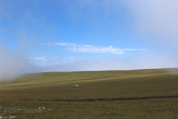 car, field and blue sky