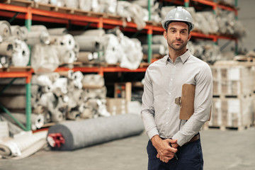 Warehouse foreman wearing a hardhat while doing inventory
