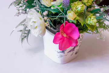 A bouquet of artificial flowers in a pot on the table. The decor of the interior. . Flowers in a pot. Beautiful flowers