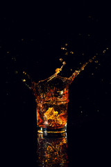 Isolated shot of whiskey with splash on black background
