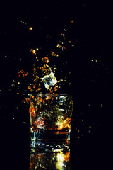 Isolated shot of whiskey with splash on black background