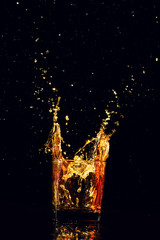 Isolated shot of whiskey with splash on black background