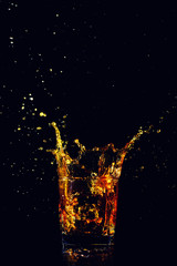 Isolated shot of whiskey with splash on black background