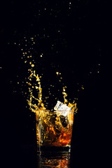 Isolated shot of whiskey with splash on black background