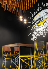 Fototapeta na wymiar Interior of cafe . Loft space design, wooden table, concrete wall. creative minimalistic cafe interior, simplicity and geometry concept, black and yellow colors.Creative space