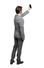 Back view of a businessman in a suit making a selfie.