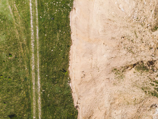 aerial view of sand connected with green field.