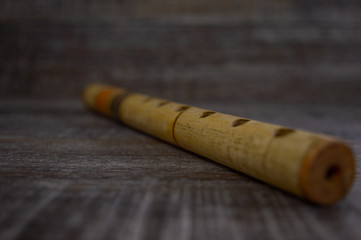Wooden musical instrument recorder isolated on a dark grey background.