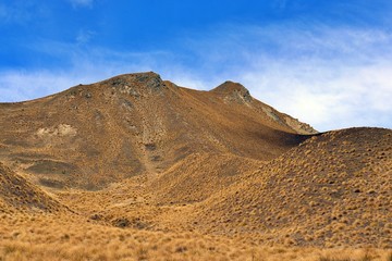 Scenic view of snow capped golden mountains in Lindis Pass against cloudy sky background,South Island,New Zealand