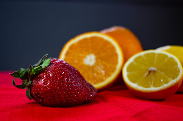 Juicy fresh slices of fruit strawberries lemons and oranges on a table.