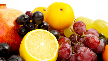 lemon, grapes and pomegranate on white background