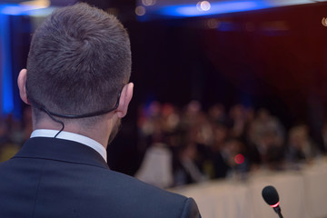Young businessman at business conference room with public giving presentations. Audience at the...