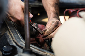 Close up on mechanic repair man electrician using hand tool combined pliers to connect copper wires on the motor engine block of the truck