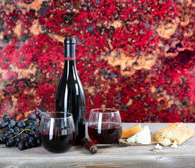 Red wine with fresh cheese and baked bread on rustic wooden table