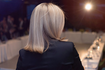 Young business woman at business conference room with public giving presentations. Audience at the conference hall. Entrepreneurship club.