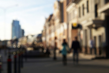 Couple of young people on the street with people and buildings on the background.
