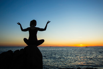 Yoga silhouette young woman on the beach amazing sunset. Relax and health.