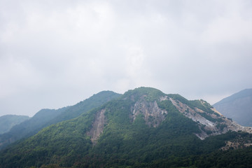 Fototapeta premium A view of Tebing Soni, Papandayan on the back side with thick vegetaion on it on cloudy grey day. Papandayan Mountain is one of the favorite place to hike on Garut.