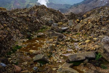 Rocky stream with brown water on a mountain. Beautiful landscape of mount Papandayan. Papandayan Mountain is one of the favorite place to hike on Garut.