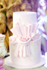 Delicious pink wedding or birthday cake decorated with bow